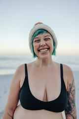 Ecstatic winter bather smiling with her eyes closed at the beach