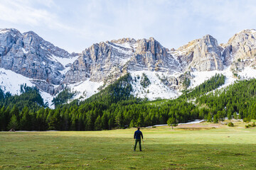 Mountain landscape with hiker and snow on the mountains.