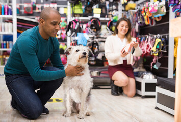 Portrait of happy man visiting pet supplies store with her cute dog
