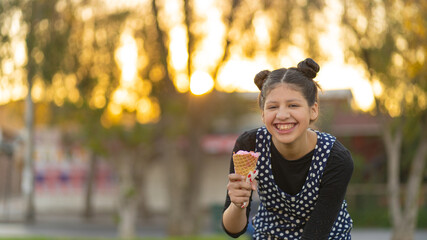 Pretty girls eating and licking big ice cream in cone with happy laughing at the park
