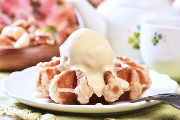 Plate of belgian waffles with ice cream on wooden table