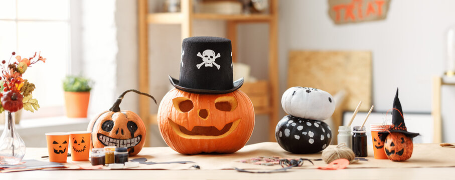 Classic carven spooky jack-o-lantern in pirate hat standing on wooden table