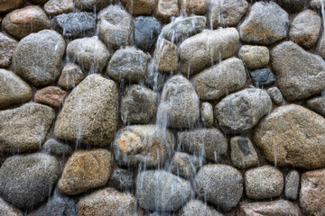 water peacefully falling over rock wall