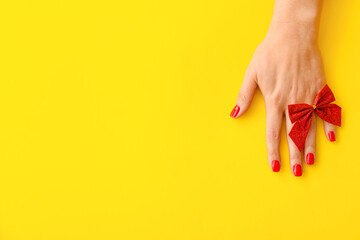 Female hand with beautiful manicure on yellow background, closeup