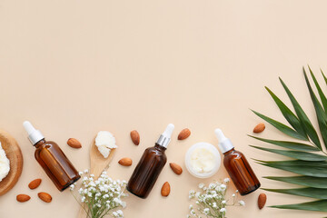 Bottles of almond essential oil on light background