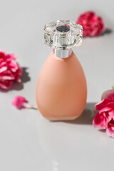 Bottle of perfume and carnation flowers on light background