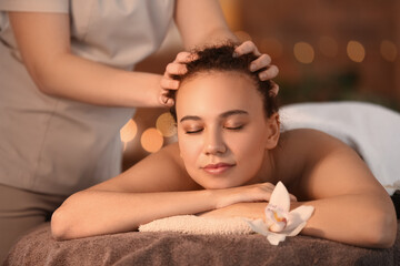 Obraz na płótnie Canvas Beautiful young African-American woman getting massage in spa salon