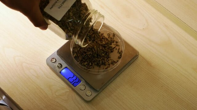 laboratory assistant in the assay laboratory to test the flower seed.
Weighing flower seeds on an electronic balance in a chemistry lab. slow motion. 4K.