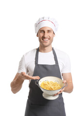 Handsome chef holding colander with spaghetti on white background