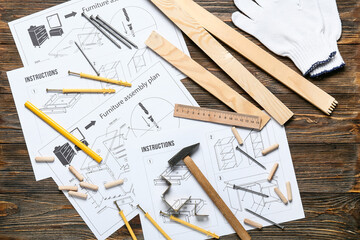 Furniture assembling plan, instructions and different tools on wooden background