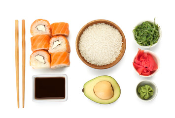 Delicious sushi rolls, bowl with soy sauce, chopsticks and ingredients on white background