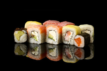 Set of different sushi and maki rolls on dark background