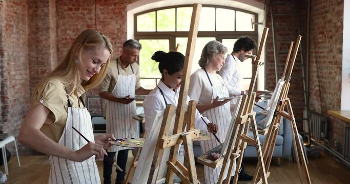 Different age and ethnicity people painting still life pictures on easel during class, learn to draw involved in arts studio. Concept of creative talented people, hobby, gaining of artistic education