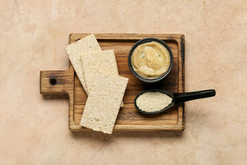 Bowl with tasty baba ghanoush, crackers and sesame on color background