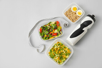 Containers with healthy food, bottle for water and measuring tape on grey background