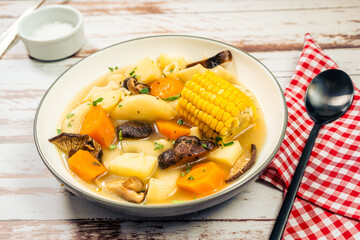 Minced view of an exquisite homemade chicken, vegetable and mushroom soup with noodles and corn. Natural and healthy food concept
