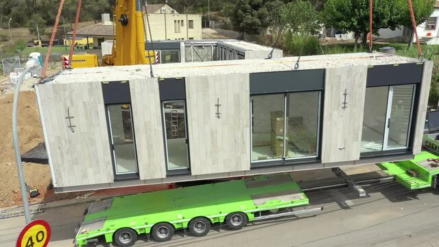 Prefabricated Building - Modular Home Lifted From A Trailer At Construction Site. - aerial