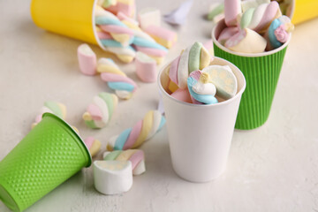 Plastic cups with tasty marshmallows on light background, closeup