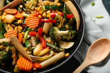 Frying pan with different vegetables on table, closeup