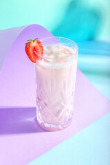 Glass of strawberry Pina Colada cocktail on color background