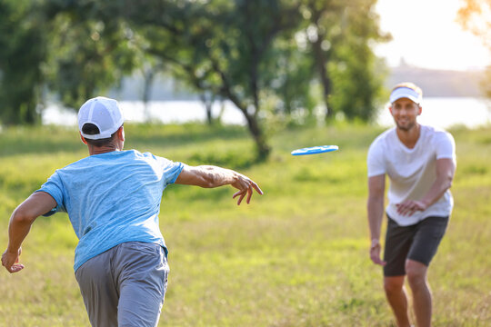 Young men playing frisbee in park