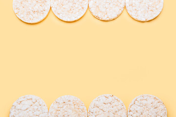 Puffed corn crackers on color background