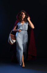 Young woman with Halloween makeup and basket on dark background