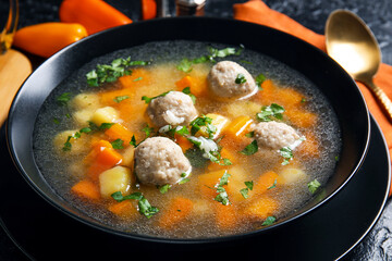 Bowl with tasty meatball soup on table, closeup