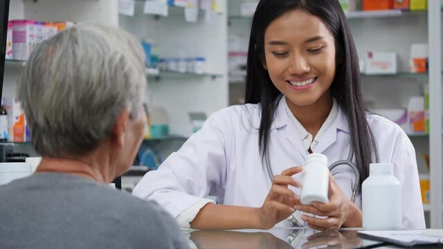 Pharmacist woman consulting to elderly female about treatment with medicine in pharmacy store at hospital. Asian senior women discuss medication with young doctor.