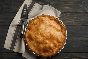 Baking dish with tasty chicken pot pie on black wooden background