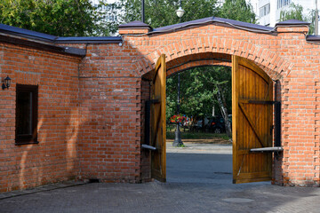 Wooden half-open gate in a brick fence in the courtyard of the 19th century merchant Kazakov's house in Kazan, Russia