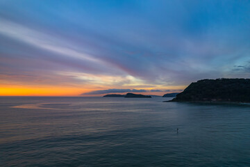 Colourful high cloud covered sunrise seascape