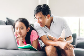 Portrait happy love asian family father teach little daughter asian girl learning and study on laptop.Dad and asian girl writing with book and pencil making homework in homeschool at home.Education