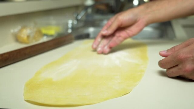 Dusting fresh egg pasta to make lasagna (slow motion shot)