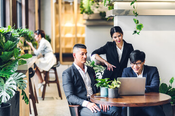 Group of professional multiethnic teamwork business discussing meeting strategy sharing idea with new startup project.Creative business people working with laptop computer in green plant terrace