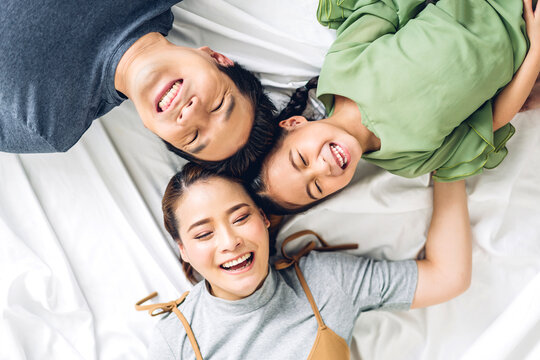 Top view of portrait enjoy happy smiling love asian family father and mother with young parent little cute asian girl looking at camera in moments good time lying on the floor at home