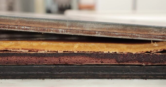 Placing Egg Custard Layer On Top Of Chocolate Cake At The Kitchen. close up, slow motion