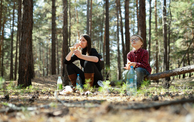 son and mother eating in the woods