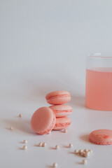 Pink macaroons with rose on marble table, Colorful cookies on white background, pastel colors. Vintage card, top view.