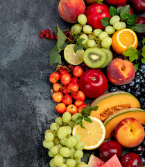 Assorted fresh fruits on dark background.