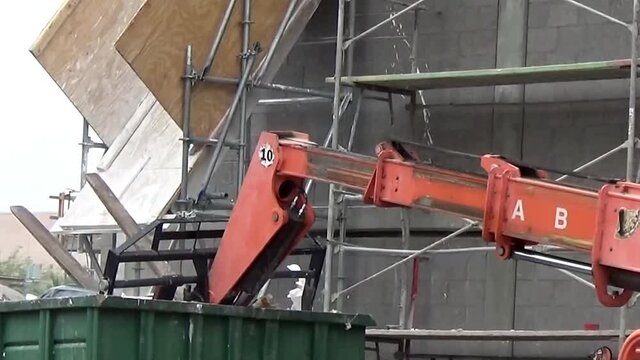 Dumpster compactor crushing trash at a construction site.