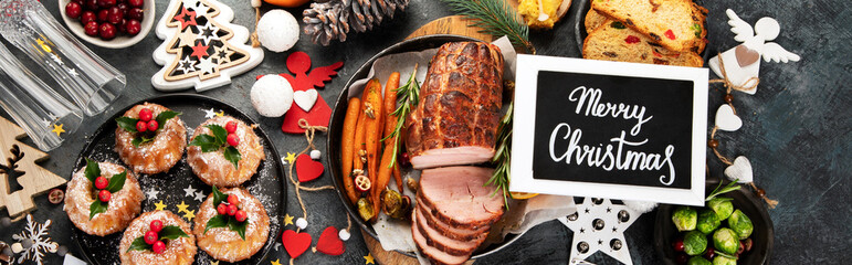 Christmas dinner table setting on dark background.