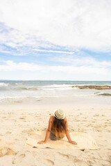 Caucasian woman lying on the white sand of a beach
