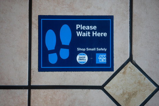 Sherwood, OR, USA - Oct 1, 2021: Social distancing footprint marker sponsored by American Express Shop Small program is seen on the floor at a local restaurant in Sherwood, Oregon, amid the pandemic.