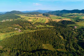 Fototapeta na wymiar Village near mountain and agricultural fields at sunset. Nature landscapem aerial view