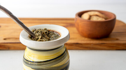 Close view of a yerba mate hot infusion opn top of a white table