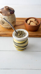 Close view of a yerba mate hot infusion opn top of a white table