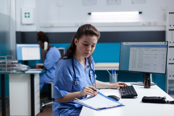 Pharmacist nurse with stethoscope analyzing healthcare treatment on medical documents typing sickness expertise working in hospital examination office. Woman asisstance checking disease results - Powered by Adobe