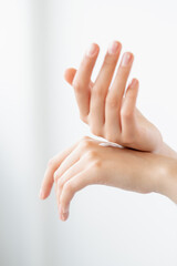 Hand moisturizing. Skin care. Hydrating treatment. Closeup of woman palms applying organic smoothing cream product on light background.
