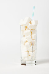 Diabetes and unhealthy diet concept. Glass of sugar cubes